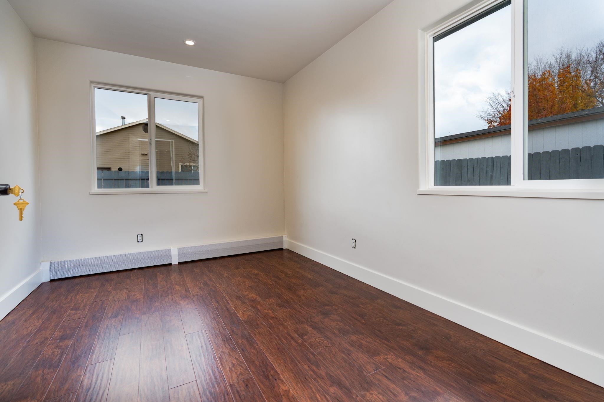 411 Cedar Glen Way Fruita, CO 81521 - Photo 21 of 25 an empty room with wooden floor and windows