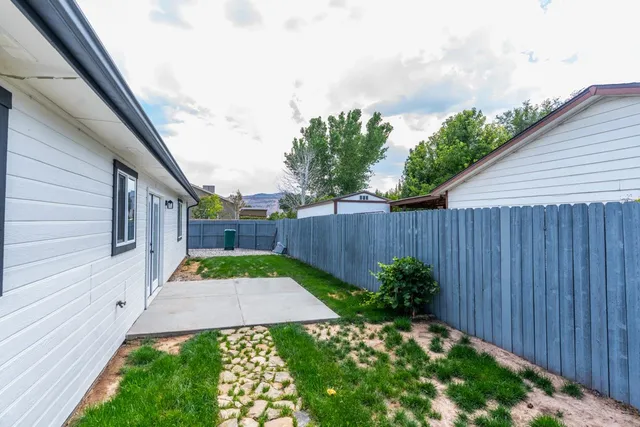 a view of backyard with potted plants and wooden fence