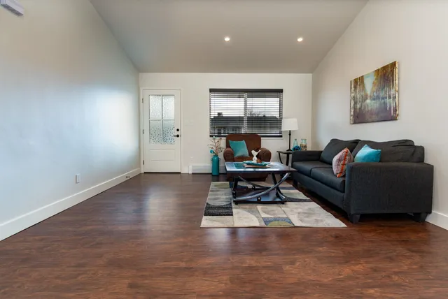 a living room with furniture and a wooden floor
