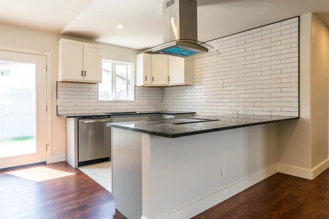 a kitchen with stainless steel appliances granite countertop a sink and a stove