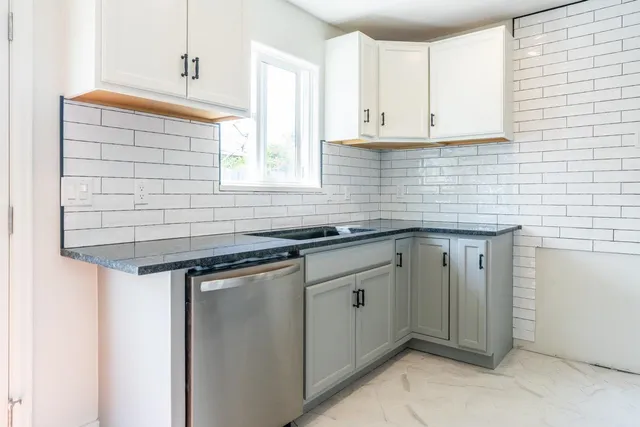 a kitchen with stainless steel appliances granite countertop a sink and cabinets