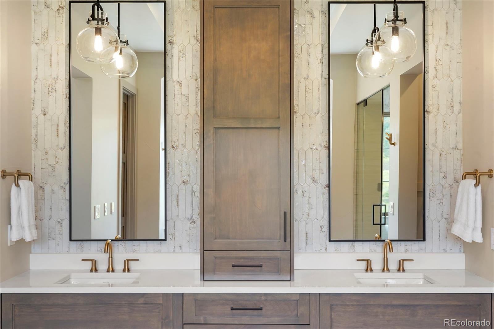 15411 Dinosaur Ridge Road Morrison, CO 80465 - Photo 22 of 50 a bathroom with a sink vanity and a mirror