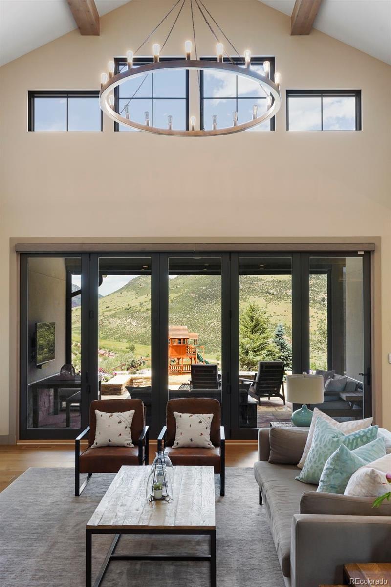 15411 Dinosaur Ridge Road Morrison, CO 80465 - Photo 5 of 50 a living room with furniture and large windows
