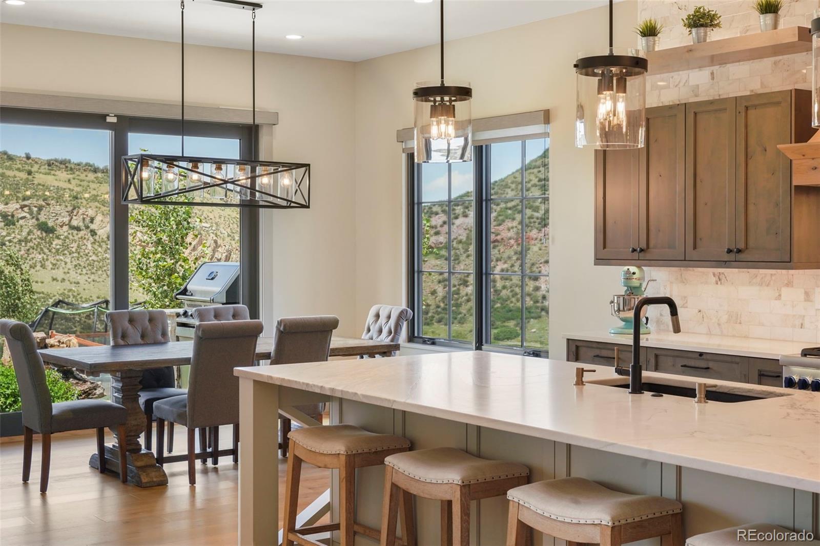 15411 Dinosaur Ridge Road Morrison, CO 80465 - Photo 8 of 50 a kitchen with a table chairs and white cabinets