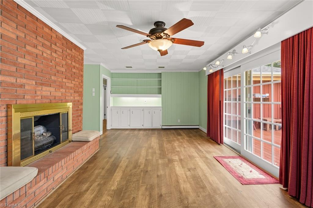 207 Forest Drive Graham, NC 27253 - Photo 15 of 34 Den w/view of FP and sliding glass doors to deck. Note Built-Ins.