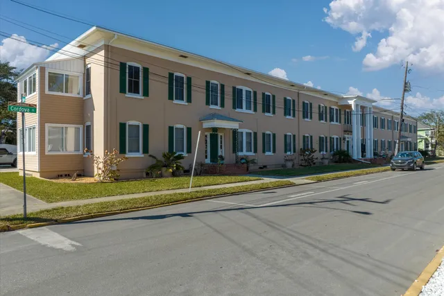 a view of a house with a big yard and large tree