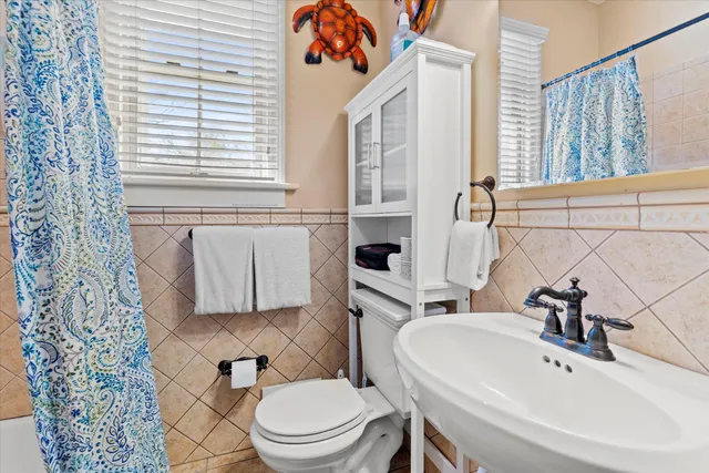 a white toilet sitting next to a bathroom sink