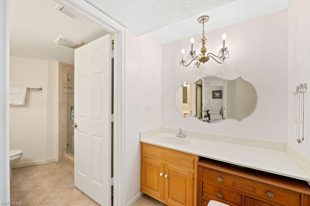 415 Augusta Boulevard, Unit 309 Naples, FL 34113 - Photo 14 of 36 a bathroom with a double vanity sink and a mirror