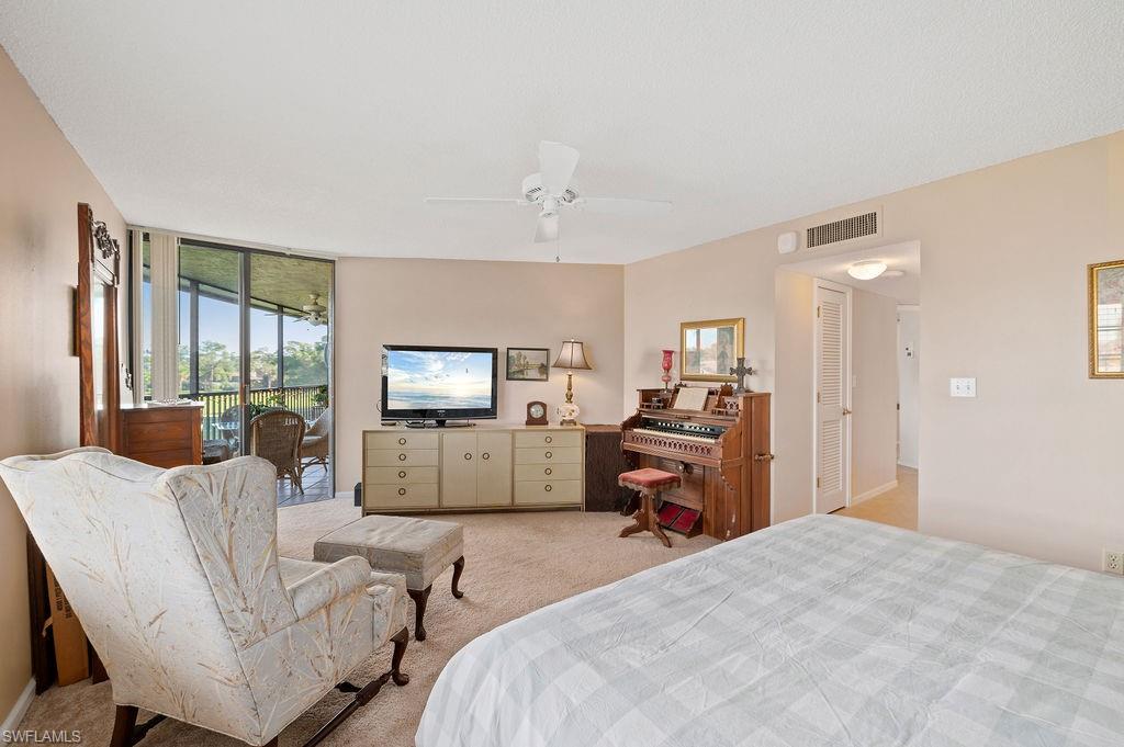 415 Augusta Boulevard, Unit 309 Naples, FL 34113 - Photo 15 of 36 a bedroom with furniture and a flat screen tv