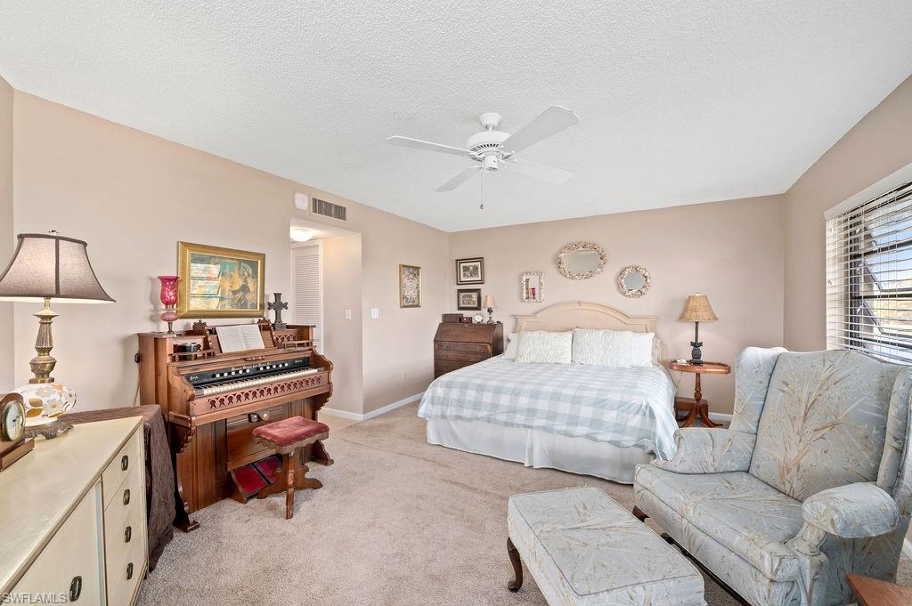 415 Augusta Boulevard, Unit 309 Naples, FL 34113 - Photo 17 of 36 a bedroom with furniture and a chandelier