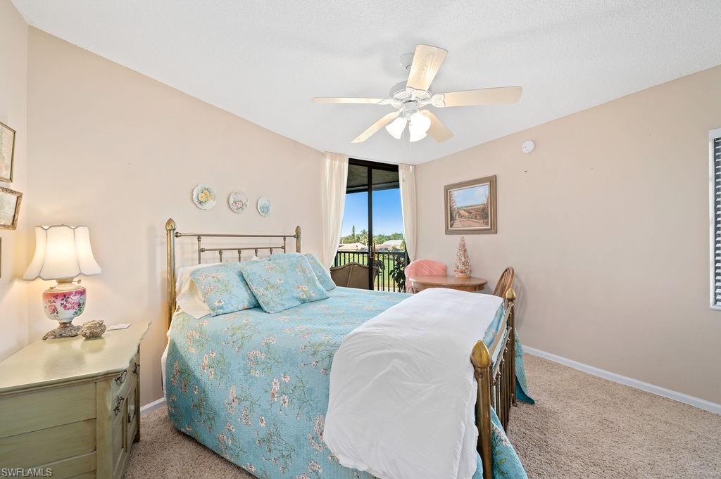 415 Augusta Boulevard, Unit 309 Naples, FL 34113 - Photo 20 of 36 a bedroom with a bed and a chandelier