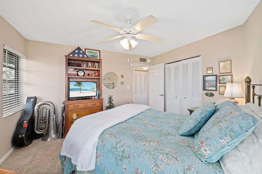 415 Augusta Boulevard, Unit 309 Naples, FL 34113 - Photo 23 of 36 a bedroom with a bed and a chandelier