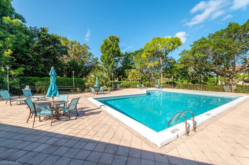 415 Augusta Boulevard, Unit 309 Naples, FL 34113 - Photo 30 of 36 a view of a swimming pool with chairs