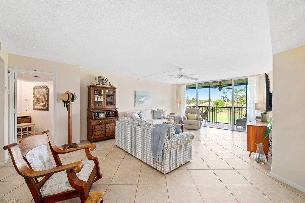 415 Augusta Boulevard, Unit 309 Naples, FL 34113 - Photo 3 of 36 a living room with furniture and a floor to ceiling window