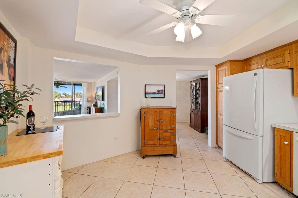 415 Augusta Boulevard, Unit 309 Naples, FL 34113 - Photo 9 of 36 a kitchen with a refrigerator a sink and a stove top oven