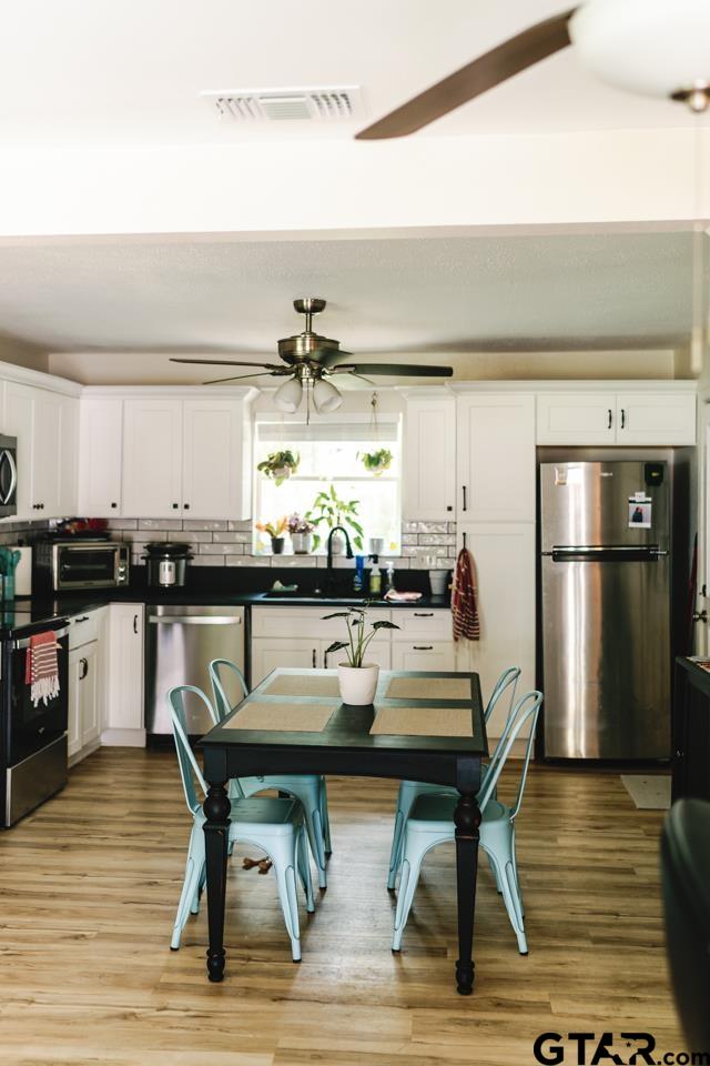 2411 Rodge Drive Tyler, TX 75701 - Photo 4 of 42 a kitchen with a table chairs refrigerator and cabinets