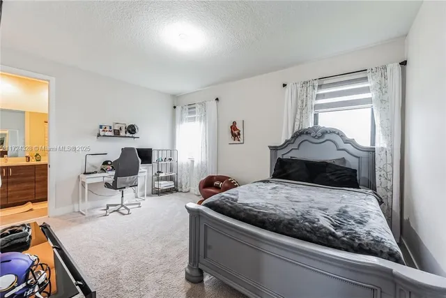 a bedroom with a bed and large windows