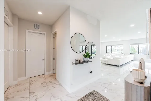 a view of a livingroom with furniture a fireplace and chandelier
