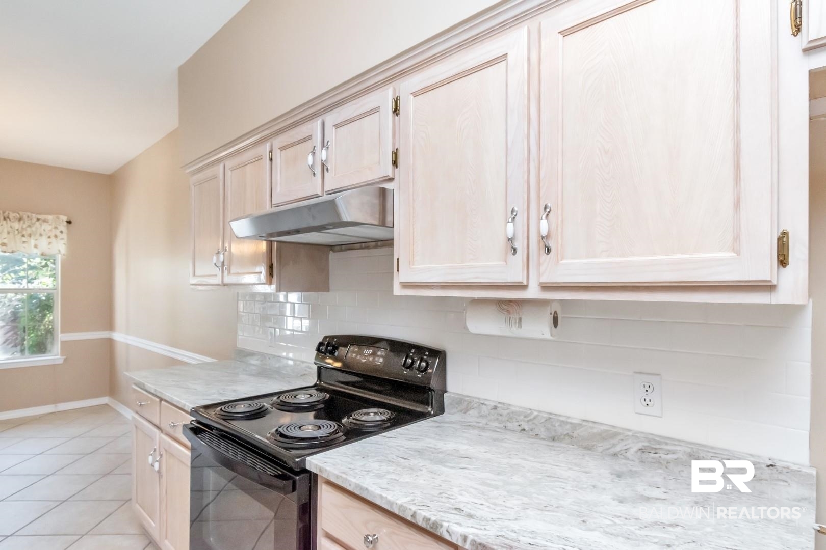 6117 Lennox Place Mobile, AL 36693 - Photo 11 of 39 Kitchen featuring light tile patterned flooring, baseboards, under cabinet range hood, black electric range, and tasteful backsplash