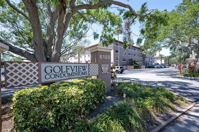 a view of a street sign under a large tree