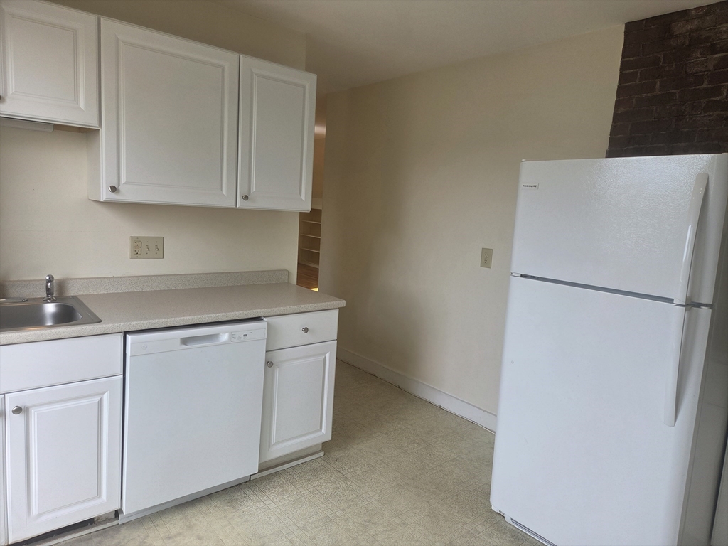 14 Hawkes Street, Unit 2 Marblehead, MA 01945 - Photo 10 of 12 a kitchen with white cabinets and refrigerator