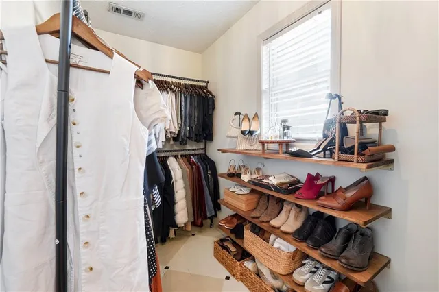 a view of walk in closet with clothes and shoes