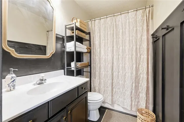 a bathroom with a sink a toilet and shower curtain