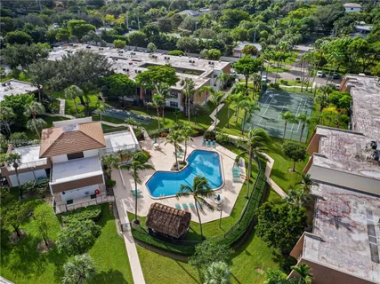 an aerial view of a house with outdoor space swimming pool patio and lake view