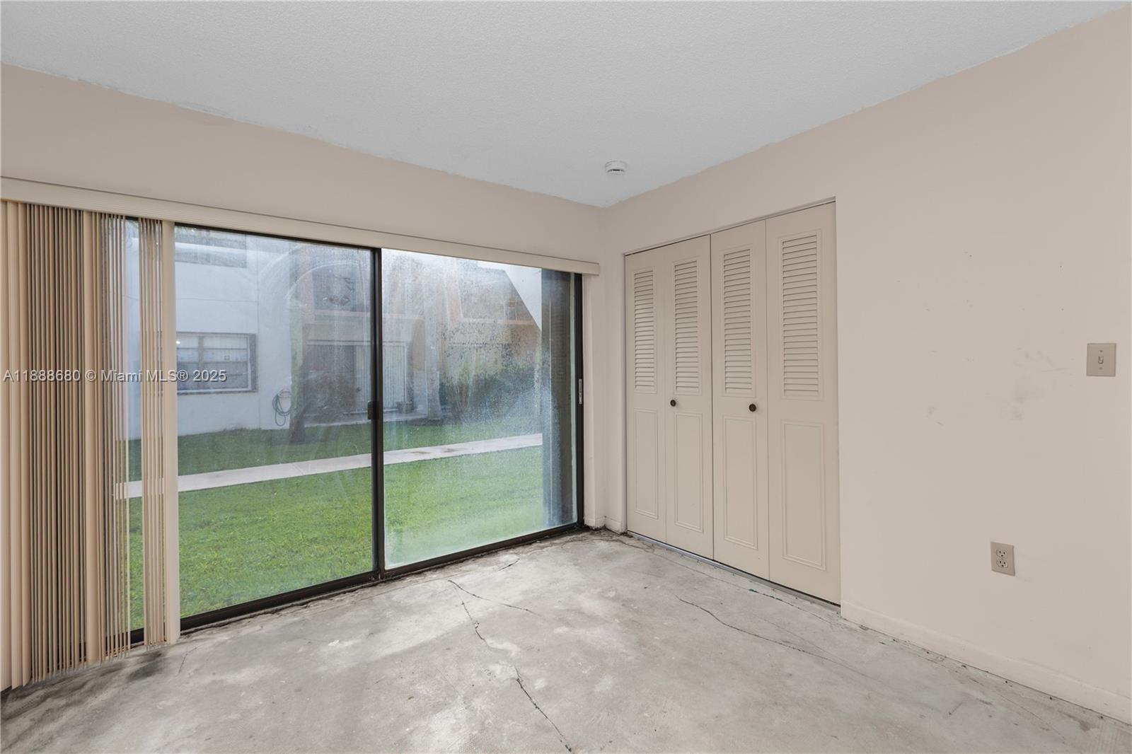 8277 Southwest 128th Street, Unit 108 Pinecrest, FL 33156 - Photo 15 of 34 a view of an empty room with sliding glass door