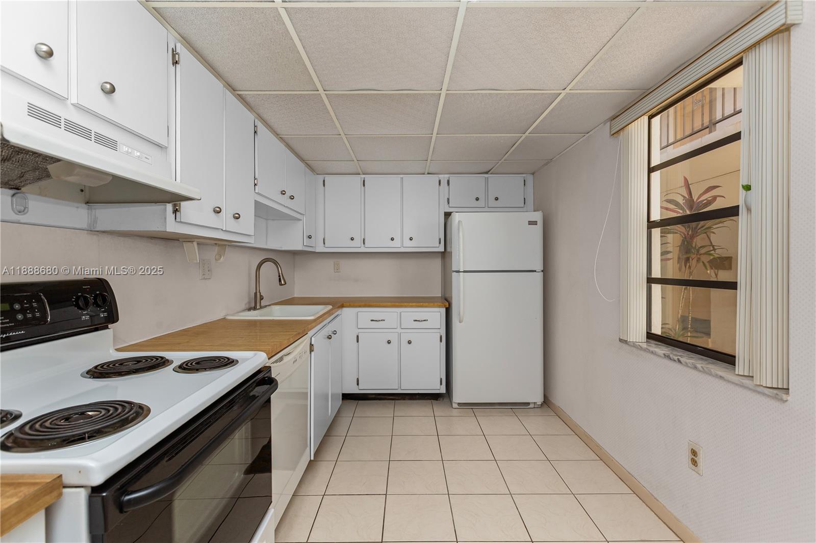 8277 Southwest 128th Street, Unit 108 Pinecrest, FL 33156 - Photo 3 of 34 a kitchen with a white stove top oven sink and cabinets