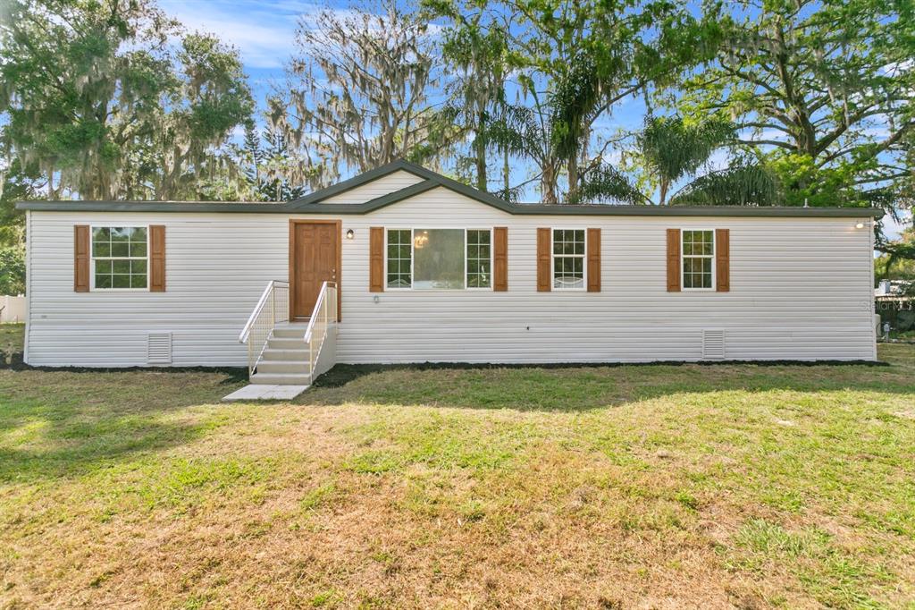 4793 Sunset Road St. Cloud, FL 34771 - Photo 1 of 28 a front view of a house with a yard