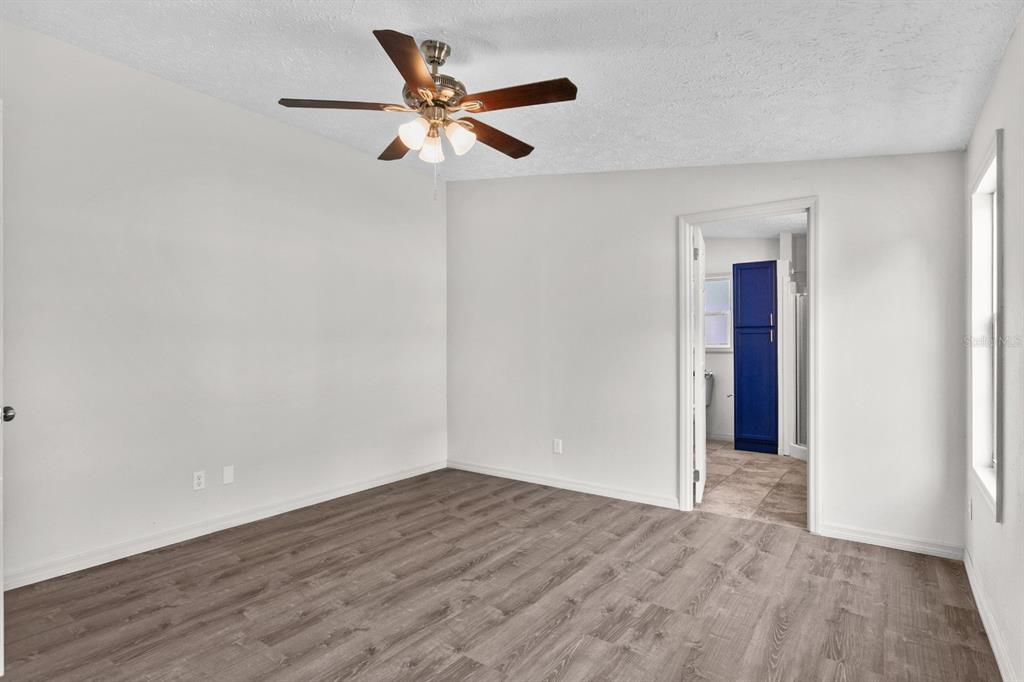 4793 Sunset Road St. Cloud, FL 34771 - Photo 11 of 28 an empty room with wooden floor and a ceiling fan