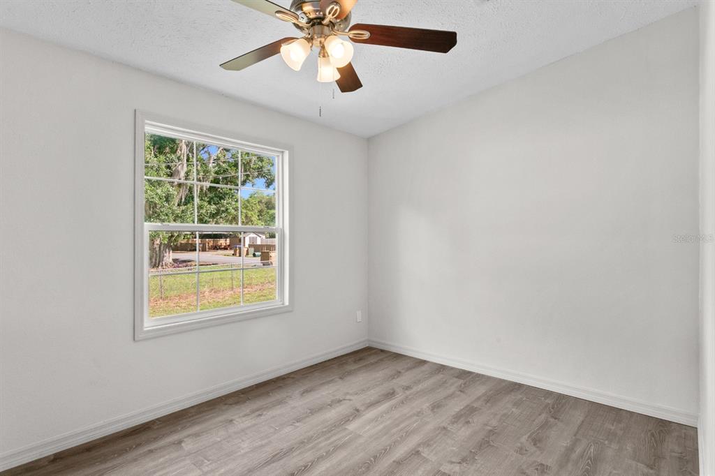4793 Sunset Road St. Cloud, FL 34771 - Photo 14 of 28 an empty room with a window and a ceiling fan