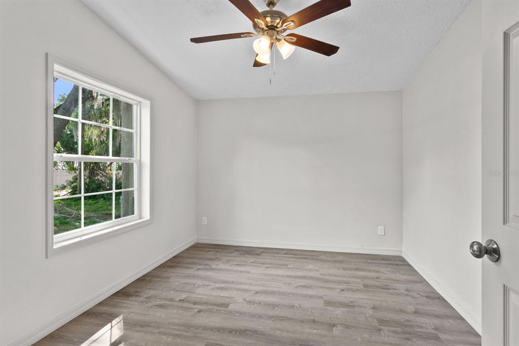 4793 Sunset Road St. Cloud, FL 34771 - Photo 16 of 28 an empty room with a window and ceiling fan