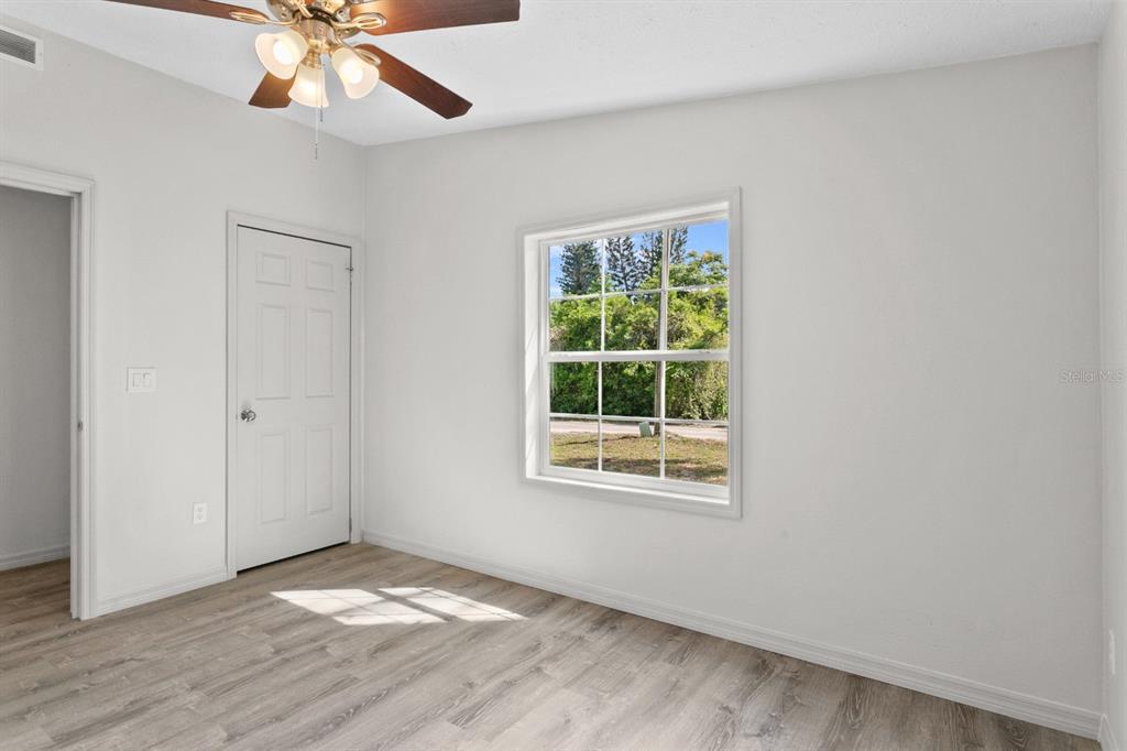 4793 Sunset Road St. Cloud, FL 34771 - Photo 17 of 28 a view of an empty room with wooden floor and a window