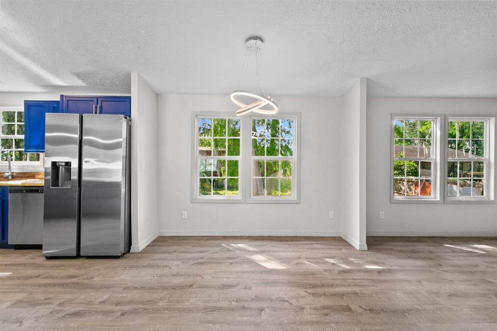 4793 Sunset Road St. Cloud, FL 34771 - Photo 6 of 28 a view of a kitchen with a fridge wooden floor and a window