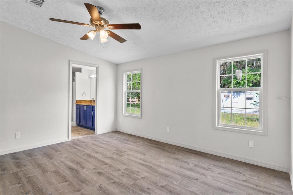 4793 Sunset Road St. Cloud, FL 34771 - Photo 10 of 28 an empty room with windows and ceiling fan