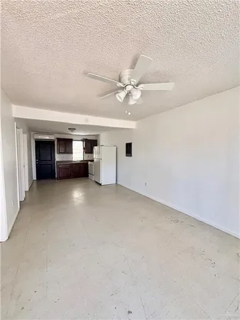 an empty room with a ceiling fan and window