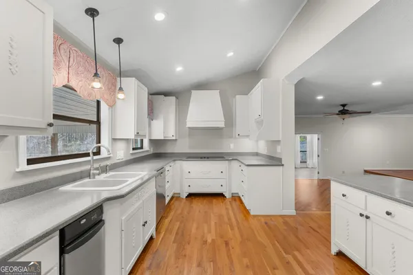 a bathroom with a granite countertop sink a mirror and shower
