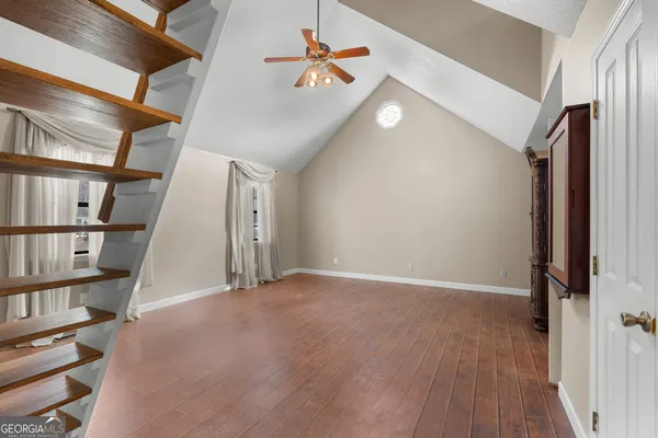 an empty room with windows and fan