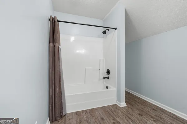 a view of a room with wooden floor and a ceiling fan