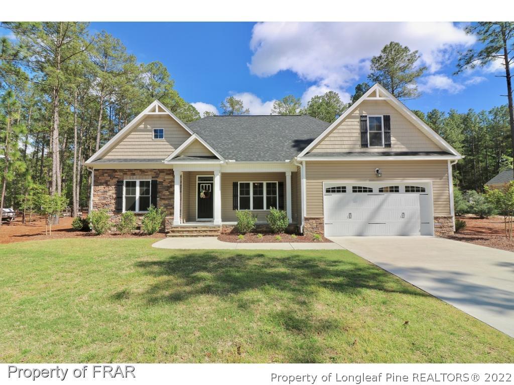 1187 Rays Bridge Road Whispering Pines, NC 28327 - Photo 1 of 35 a front view of a house with a garden and porch