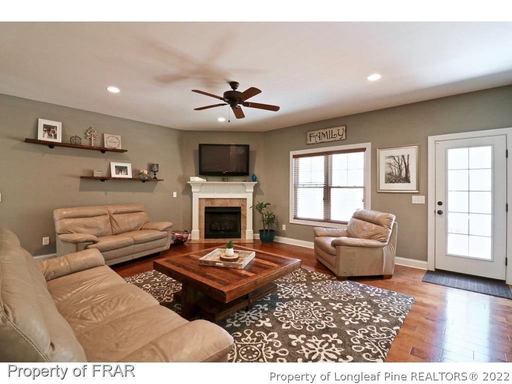 1187 Rays Bridge Road Whispering Pines, NC 28327 - Photo 12 of 35 a living room with furniture a fireplace and a flat screen tv