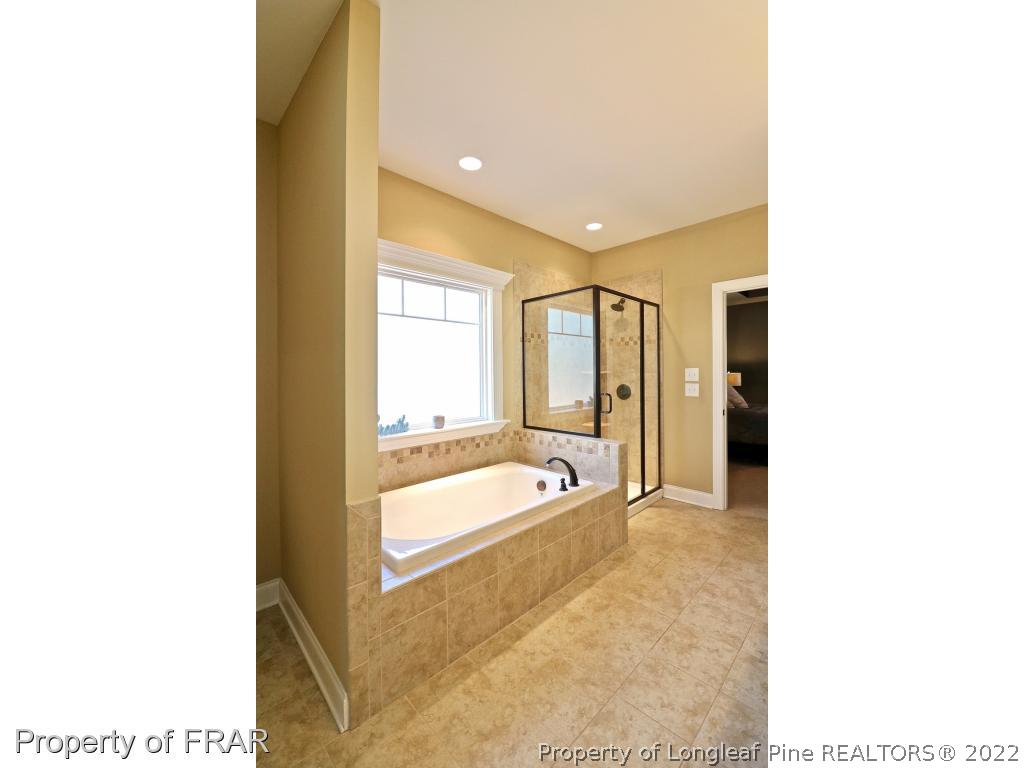 1187 Rays Bridge Road Whispering Pines, NC 28327 - Photo 16 of 35 a bathroom with a tub shower and sink