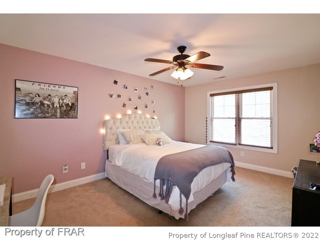 1187 Rays Bridge Road Whispering Pines, NC 28327 - Photo 20 of 35 a bedroom with a large bed and a chandelier