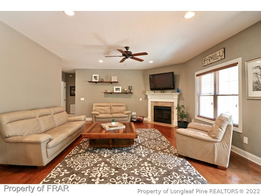1187 Rays Bridge Road Whispering Pines, NC 28327 - Photo 2 of 35 a living room with furniture a fireplace and a flat screen tv