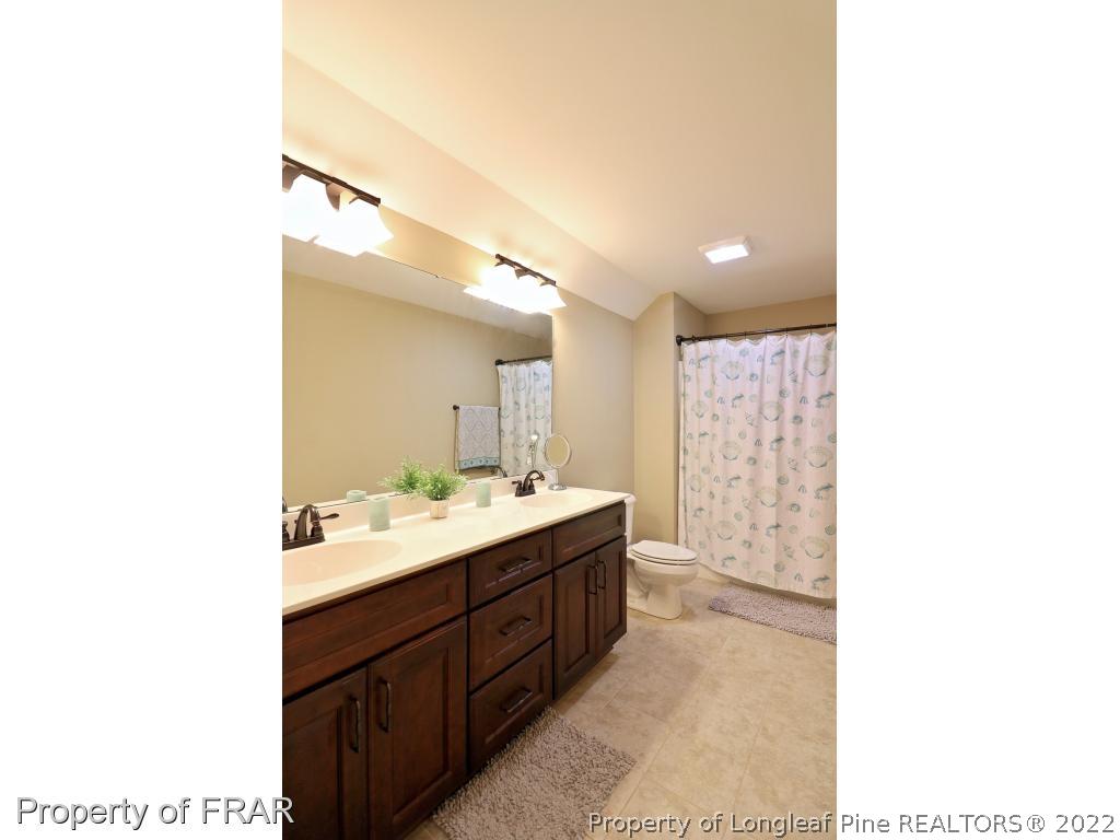 1187 Rays Bridge Road Whispering Pines, NC 28327 - Photo 21 of 35 a bathroom with a sink a toilet and mirror