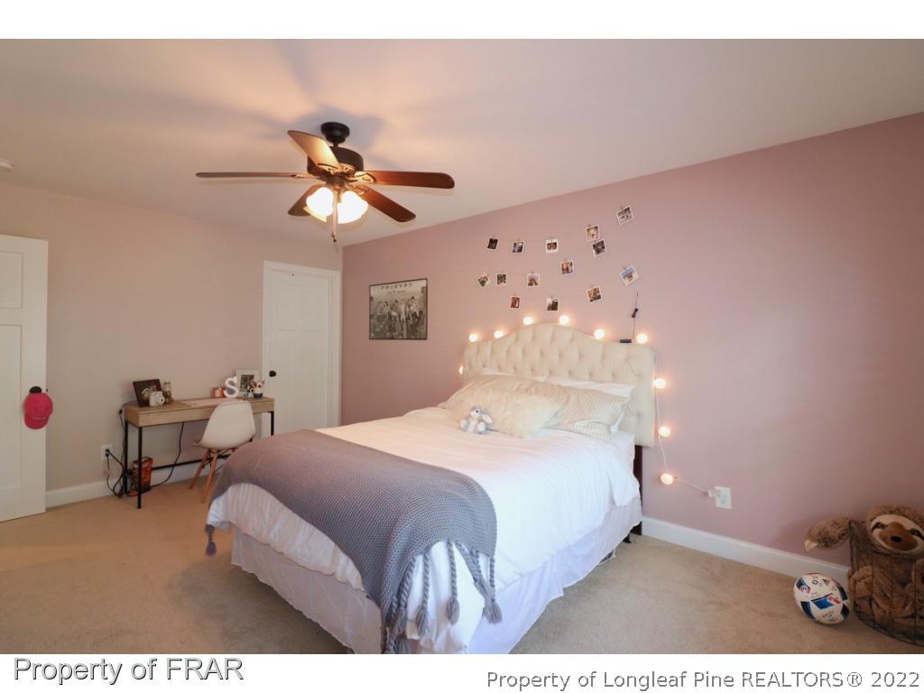 1187 Rays Bridge Road Whispering Pines, NC 28327 - Photo 22 of 35 a bedroom with a bed and a chandelier