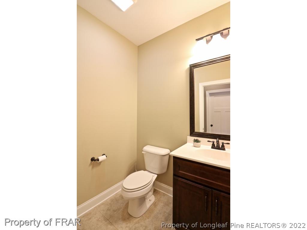 1187 Rays Bridge Road Whispering Pines, NC 28327 - Photo 24 of 35 a bathroom with a toilet a sink and mirror
