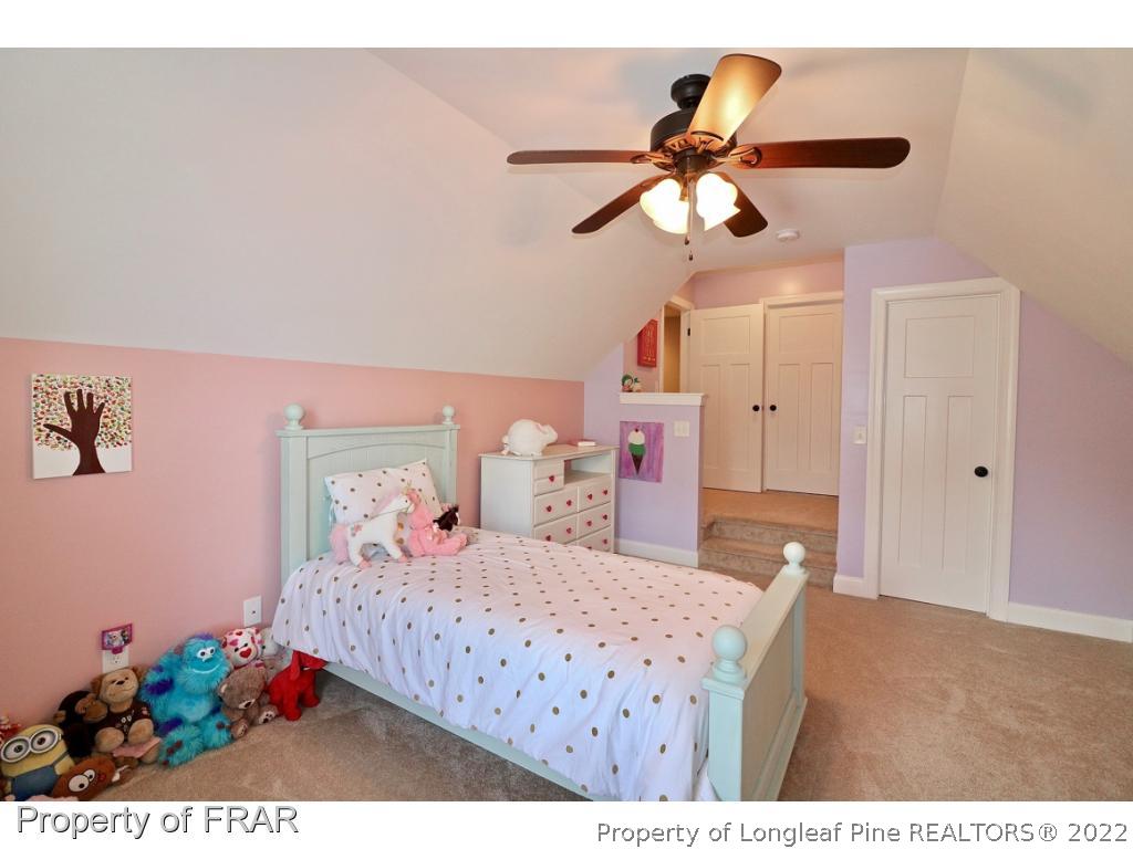 1187 Rays Bridge Road Whispering Pines, NC 28327 - Photo 25 of 35 a bedroom with a bed and a chandelier